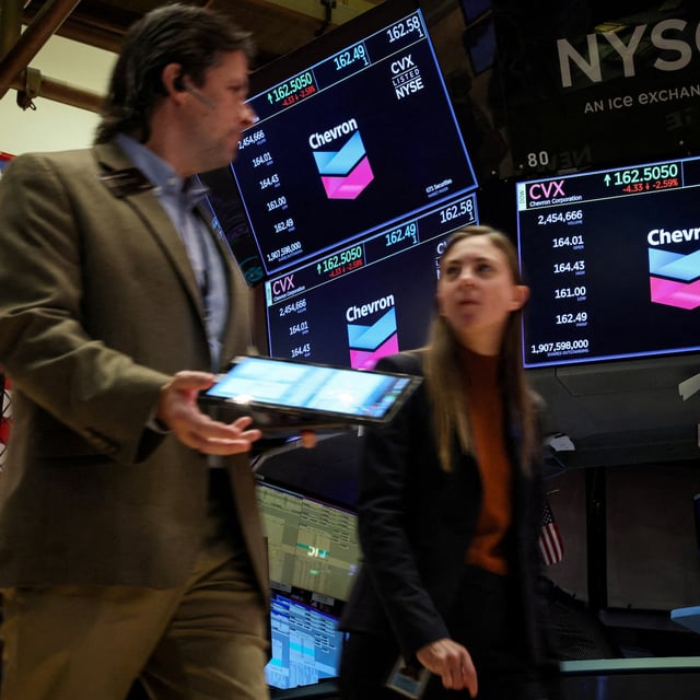 FILE PHOTO: Traders work on the floor as screens display the logo for Chevron Corp. at the New York Stock Exchange (NYSE) in New York City, U.S., October 23, 2023.  REUTERS/Brendan McDermid/File Photo