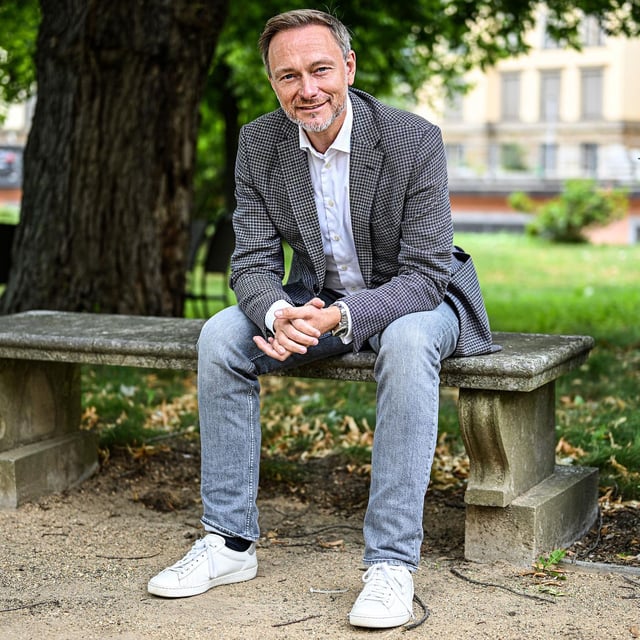Finanzminister Christian Lindner (FDP), 2023 während eines Interviews auf einer Parkbank sitzend 