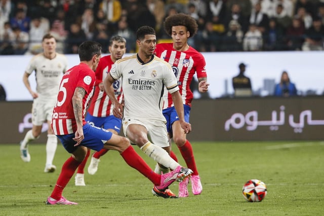 El centrocampista del Real Madrid Jude Bellingham juega un balón entre Stefan Savic y Axel Witsel.