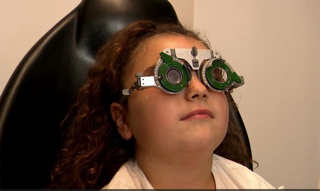 Una niña en la óptica haciéndose pruebas.