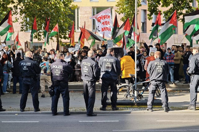 Personen in den Uniformen der Berliner Polizei besichtigen eine Palästina anti-Israel Demo