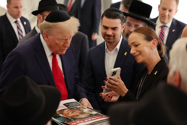 Then-Republican presidential nominee, U.S. President Donald Trump, is shown photos of Edan Alexander by his mother Yael Alexander at Ohel Chabad Lubavitch on Oct. 7, 2024 in New York City