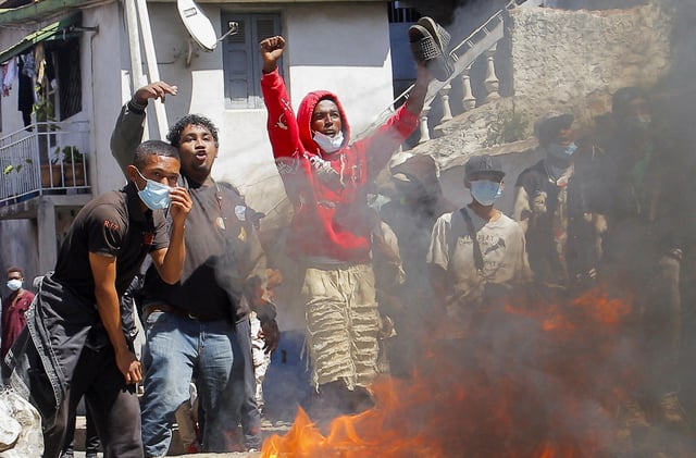 Protesters gestures near a burning barricade during a nationwide youth-led demonstration over frequent power outages and water shortages, in Antananarivo, Madagascar, October 6, 2025. REUTERS/Zo Andrianjafy