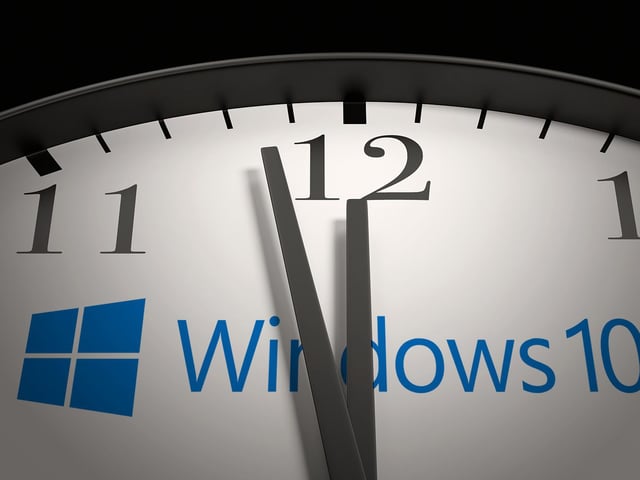 Windows 10 logo on a clock close to striking midnight.