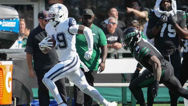 Oct 5, 2025; East Rutherford, New Jersey, USA; Dallas Cowboys wide receiver Ryan Flournoy (19) runs with the ball as New York Jets safety Andre Cisco (8) defends during the first half at MetLife Stadium. Mandatory Credit: Robert Deutsch-Imagn Images