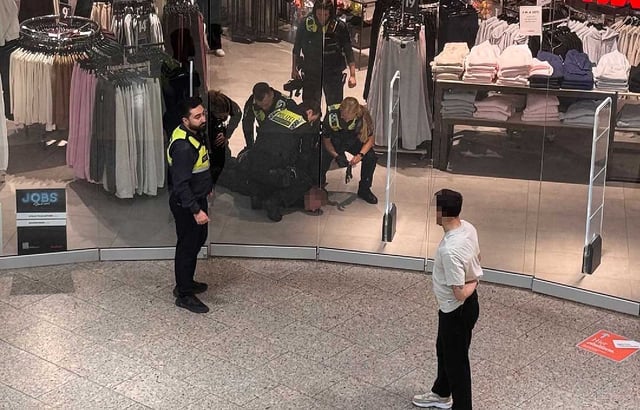 Polizisten nehmen einen Tatbeteilgten fest.