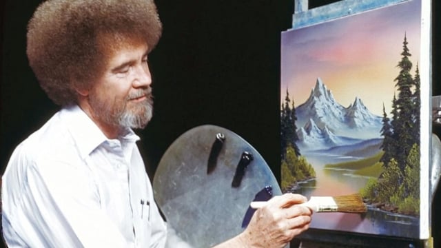 Bob Ross paints a mountainous scene in his TV show The Joy of Painting. Thirty of the artist's works will be auctioned off in support of public TV stations.