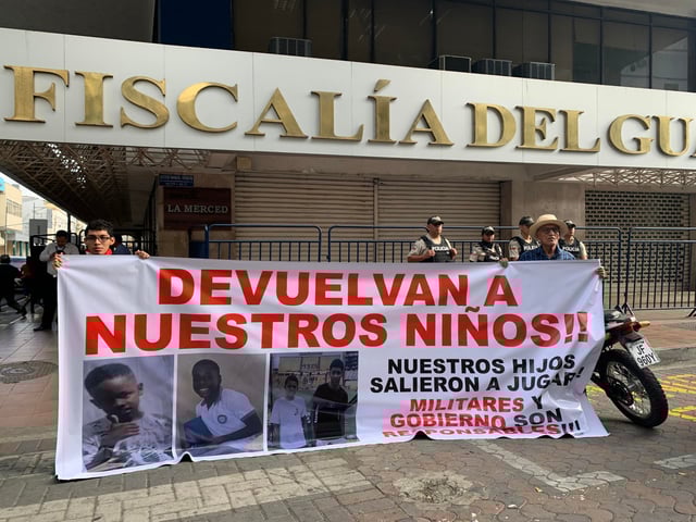 Dos personas sosteniendo un cartel en los exteriores de la Fiscalía Provincial del Guayas con el mensaje "devuelvan a nuestros niños", en alusión a los cuatro menores desaparecidos el 8 de diciembre en Guayaquil (Ecuador). EFE/Cristina Bazán