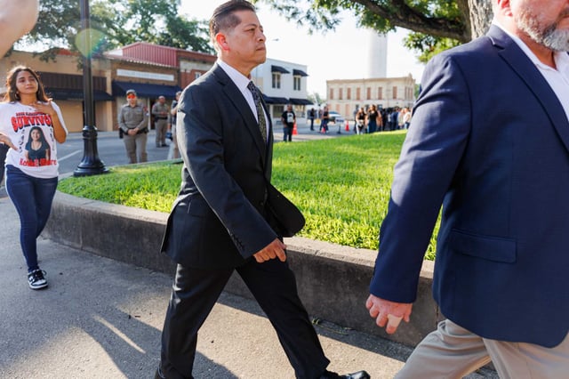 Adrian Gonzales, center, leaves the Uvalde County Courthouse as Cristine Olivarez, whose daughter survived the 2022 Robb Elementary School shooting, walks behind him on July 25, 2024. Gonzales, a former Uvalde school police officer, is charged with child abandonment in connection with the police response to the 2022 Robb Elementary shooting.