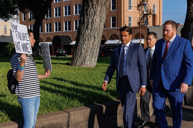 James Alvarado, left, holds signs that say “Your failure! not mine!” and “Remember their names” as Adrian Gonzales, flanked by two defense lawyers, walks toward the Uvalde County Courthouse for a hearing. Gonzales, a former Uvalde school police officer, is charged with child abandonment in connection with the police response to the 2022 Robb Elementary School shooting.
 
 
on Thursday, July 25, 2024, in Uvalde, Texas. Gonzales and former UCISD police Chief Pete Arredondo were indicted by a Uvalde grand jury in late June following an investigation into the shooting.