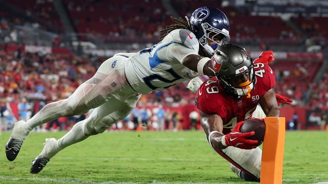 Aug 9, 2025; Tampa, Florida, USA; Tampa Bay Buccaneers running back Owen Wright (49) dives into the end zone on a play that was celled back for holding past Tennessee Titans defensive back Julius Wood (24) in the fourth quarter during a preseason game at Raymond James Stadium. Mandatory Credit: Nathan Ray Seebeck-Imagn Images.