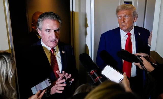 President Donald Trump watches as Interior Secretary Doug Burgum speaks to reporters aboard Air Force One while en route to Joint Base Andrews, Md. after attending a memorial for conservative activist Charlie Kirk in Glendale, Ariz., Sunday, Sept. 21, 2025.