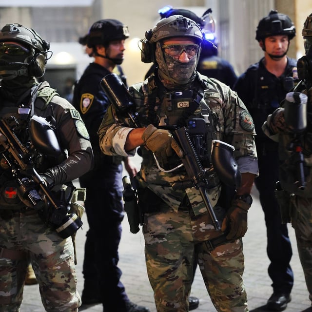 PORTLAND, OREGON - OCTOBER 06: Federal agents, including members of the Department of Homeland Security, the Border Patrol, and police officers, attempt to keep protesters back outside a downtown U.S. Immigration and Customs Enforcement (ICE) facility on October 06, 2025 in Portland, Oregon. The facility has become a focal point of nightly protests against the Trump administration and his announcement that he will be sending National Guard troops into Portland.   (Photo by Spencer Platt/Getty Images)