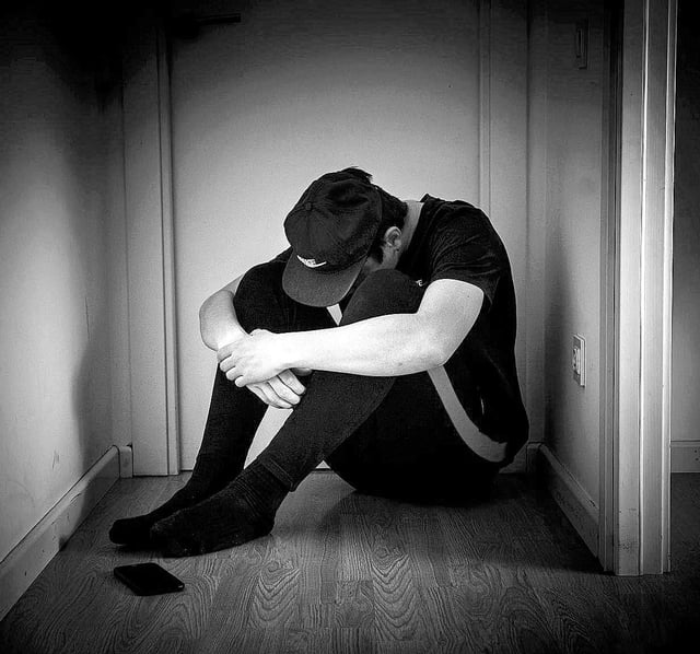 Un hombre se muestra abatido en un rincón de su casa.