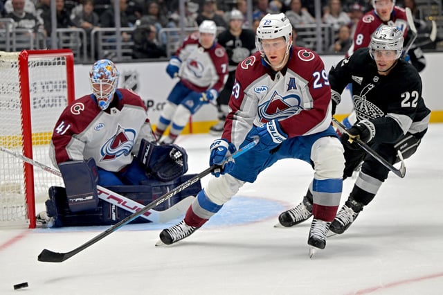Oct 7, 2025; Los Angeles, California, USA;  Colorado Avalanche center Nathan MacKinnon (29) controls the puck away from Los Angeles Kings left wing Kevin Fiala (22) during the second period at Crypto.com Arena. Mandatory Credit: Jayne Kamin-Oncea-Imagn Images