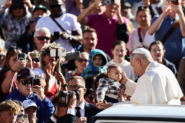 Pope Leo XIV blesses a child as he arrives for a general audience in St. Peter's Square at the Vatican, October 8, 2025. REUTERS/Yara Nardi