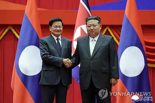 North Korean leader Kim Jong-un (R) shakes hands with Lao President Thongloun Sisoulith in Pyongyang on Oct. 7, 2025, as the Lao official visited the North to attend celebrations marking the 80th anniversary of the founding of the Workers' Party of Korea, in this undated photo released by the North's official Korean Central News Agency on Oct. 8. (For Use Only in the Republic of Korea. No Redistribution) (Yonhap)