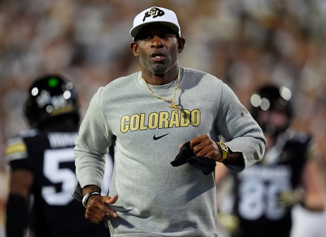 Colorado football coach Deion Sanders runs on the field before his team's game against Wyoming at Folsom Field.