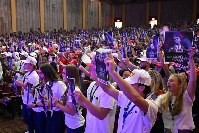Attendees hold posters with a photo Charlie Kirk during an "American Comeback Tour" stop hosted by Turning Point USA in Burruss Hall at Virgina Tech university in Blacksburg, Virginia, on September 24, 2025. The event is being held two weeks after the killing of right-wing activist and co-founder of Turning Point USA Charlie Kirk during an "American Comeback Tour" stop in Orem, Utah on September 10. (Photo by Alex WROBLEWSKI / AFP) (Photo by ALEX WROBLEWSKI/AFP via Getty Images)