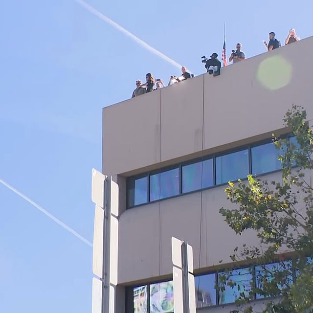 U.S. Department of Homeland Security Secretary Kristi Noem, second from left, looks down from the roof of the ICE facility in Portland, Oregon on Tuesday, Oct. 7, 2025. During her visit to Portland, Noem met with Oregon Gov. Tina Kotek and toured the ICE facility. (KATU)