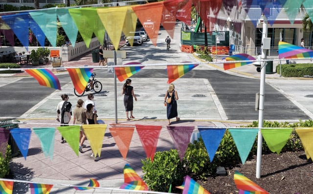 Pride flags fly near the intersection where the Florida Department of Transportation removed the LGBTQ+ rainbow crosswalk and replaced it with black pavement. (Joe Raedle/Getty Images)