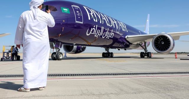 A man takes a photo of a Boeing 787-9 Dreamliner passenger aircraft, operated by Riyadh Air, at the Dubai Air Show in 2023. Bloomberg