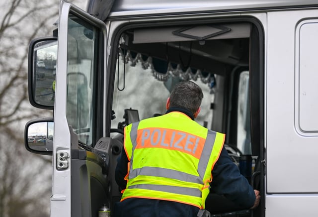 Ein Polizist kontrolliert einen Sattelzug (Symbolbild).