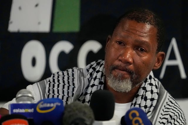 Mandla Mandela speaks to journalists after their arrival with members of the Global Sumud Flotilla, at OR Tambo International Airport, in Johannesburg, South Africa, Wednesday, Oct. 8, 2025. (AP Photo/Themba Hadebe)