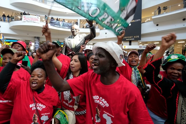 Activists sing as they welcome the members of the Global Sumud Flotilla, at OR Tambo International Airport, in Johannesburg, South Africa, Wednesday, Oct. 8, 2025. (AP Photo/Themba Hadebe)