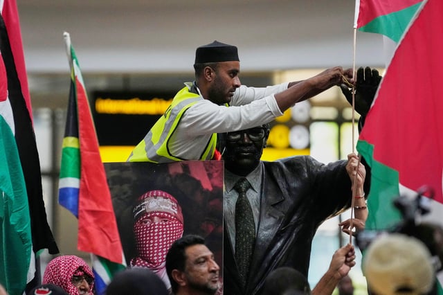 Activists prepare to welcome of members of the Global Sumud Flotilla, at OR Tambo International Airport, in Johannesburg, South Africa, Wednesday, Oct. 8, 2025. (AP Photo/Themba Hadebe)