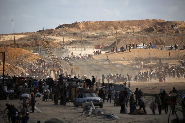 Palestinos llevando comida que recibieron de un punto de distribución de la Fundación Humanitaria de Gaza en las inmediaciones del corredor de Netsarim. (Foro: Eyad BABA / AFP)