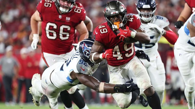 Aug 9, 2025; Tampa, Florida, USA; Tampa Bay Buccaneers running back Owen Wright (49) runs with the ball as Tennessee Titans linebacker Jaylen Harrell (92) defends during the second half at Raymond James Stadium. Mandatory Credit: Kim Klement Neitzel-Imagn Images
