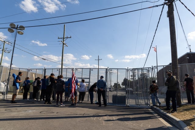 Protesters yell at federal agents behind a gate during a protest at an Immigration and Customs Enforcement holding facility in Broadview on Saturday, Oct. 4, 2025. (Dominic Di Palermo/Chicago Tribune)