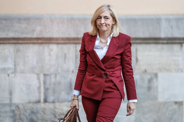 Nina Warken schaut skeptisch und trägt eine Aktentasche in de Händen