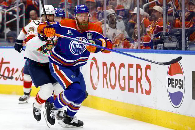Jun 6, 2025; Edmonton, Alberta, CAN; Edmonton Oilers defenseman Mattias Ekholm (14) and Florida Panthers center Sam Reinhart (13) skate for a puck during the second period in game two of the 2025 Stanley Cup Final at Rogers Place. Mandatory Credit: Perry Nelson-Imagn Images