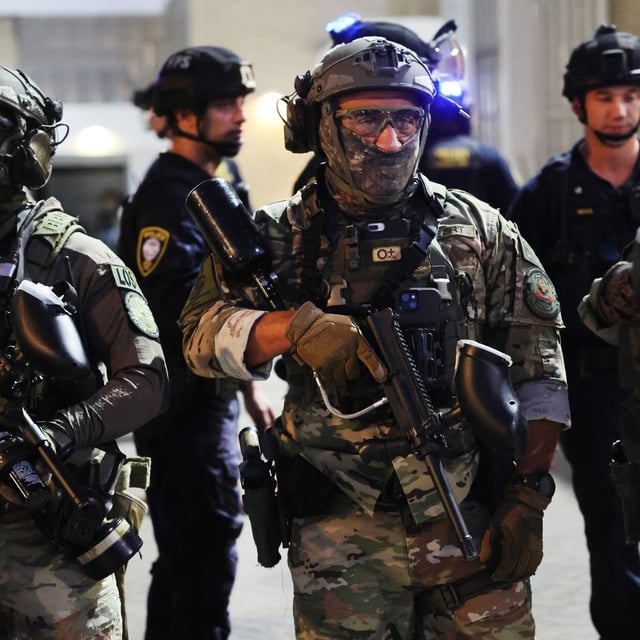PORTLAND, OREGON - OCTOBER 06: Federal agents, including members of the Department of Homeland Security, the Border Patrol, and police officers, attempt to keep protesters back outside a downtown U.S. Immigration and Customs Enforcement (ICE) facility on October 06, 2025 in Portland, Oregon. The facility has become a focal point of nightly protests against the Trump administration and his announcement that he will be sending National Guard troops into Portland.   (Photo by Spencer Platt/Getty Images)