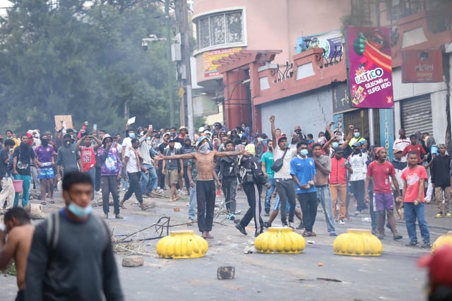 Demonstrators protesting against chronic electricity and water cuts confront riot police in Antananarivo, Madagascar, Tuesday, Sept. 30, 2025. (AP Photo/Mamyrael)