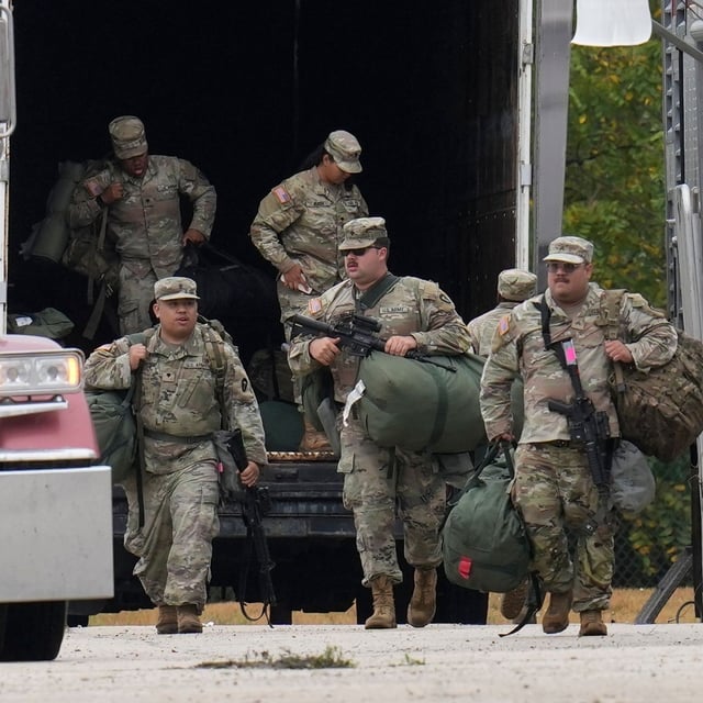 Military personnel in uniform, with the Texas National Guard patch on, are seen at the U.S. Army Reserve Center, Tuesday, Oct. 7, 2025, in Elwood, Ill., a suburb of Chicago. (AP Photo/Erin Hooley)