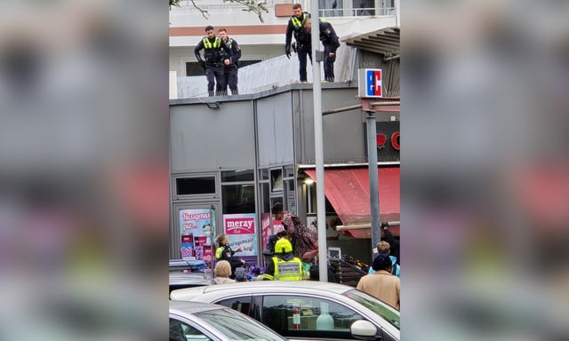 Die Frau sprang auf die Markise eines Gemüseladens.