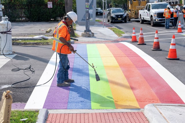 A worker applies heat to cure the paint as the rainbow crosswalk is repainted at Westheimer Road and Taft Street in Houston, Wednesday, Oct. 1, 2025.