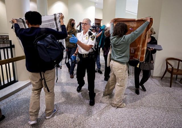 A court officers clears the area outside of a courtroom, Wednesday, Octoboer 8, at Boston Municipal Court, where arraignments were held for protesters. (Mark Stockwell/Boston Herald)
