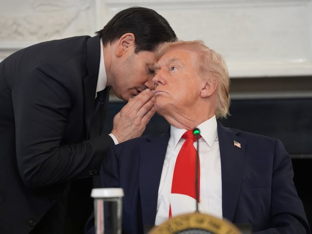 Secretary of State Marco Rubio whispers to President Donald Trump, who is holding the note Rubio handed to him, during a roundtable meeting on antifa in the State Dining Room at the White House, Wednesday, Oct. 8, 2025, in Washington. (AP Photo/Evan Vucci)