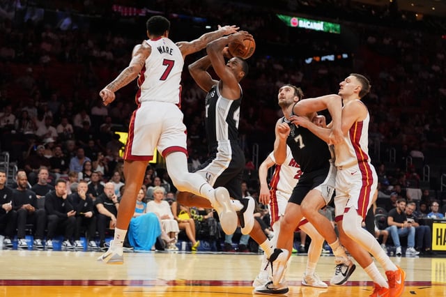Miami Heat center Kel'el Ware (7) attempts to block a shot by San Antonio Spurs forward Harrison Barnes (40) during the first half of a preseason NBA basketball game, Wednesday, Oct. 8, 2025, in Miami. (AP Photo/Rebecca Blackwell)