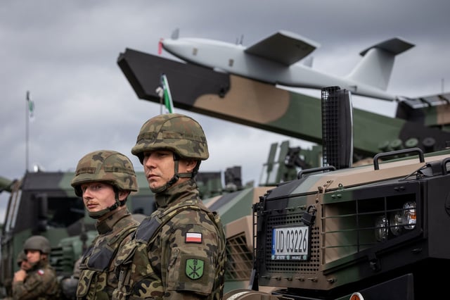 Polish soldiers stand next to a Polish "Waran" armored multipurpose vehicle equipped with the Gladius drone system, during a military equipment display following military exercises of Poland and NATO allied countries in Orzysz, northwestern Poland, on September 17, 2025.