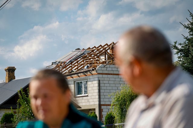 A couple sits as police inspect damage to their house, destroyed by debris from a shot-down Russian drone in the village of Wyryki-Wola, eastern Poland, on September 10, 2025.