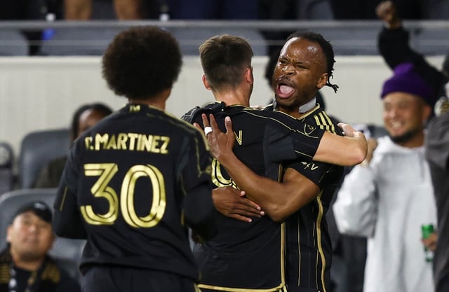 LAFC forward Jeremy Ebobisse, right, celebrates with midfielder Andy Moran, center, after scoring a goal as forward David Martínez (30) arrives to join the fun during the first half of their MLS match against Toronto FC on Wednesday night at BMO Stadium. LAFC won, 2-0. (AP Photo/Jessie Alcheh)