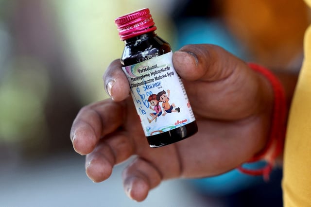 Nilesh Suryavanshi, 32, the father of a 3 year old child who has been admitted at the Government Medical College, holds a bottle of Coldrif cough syrup, which has been linked to the deaths of 17 children, in Nagpur, India, October 8, 2025. REUTERS/Priyanshu Singh