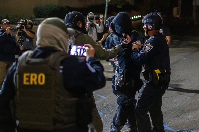 A protester is arrested by police and federal officers outside a U.S. Immigration and Customs Enforcement facility in Portland, Ore., Monday, Oct. 6, 2025. (AP Photo/Ethan Swope)
