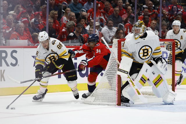 Oct 8, 2025; Washington, District of Columbia, USA; Boston Bruins right wing David Pastrnak (88) skates with the puck against behind Bruins goaltender Jeremy Swayman (1) as Washington Capitals right wing Justin Sourdif (34) chases during the first period at Capital One Arena. Mandatory Credit: Geoff Burke-Imagn Images