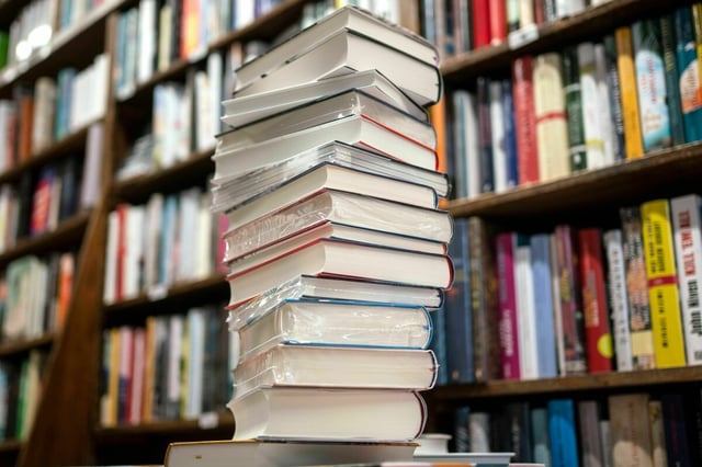 Bücherstapel vor Bücherregal